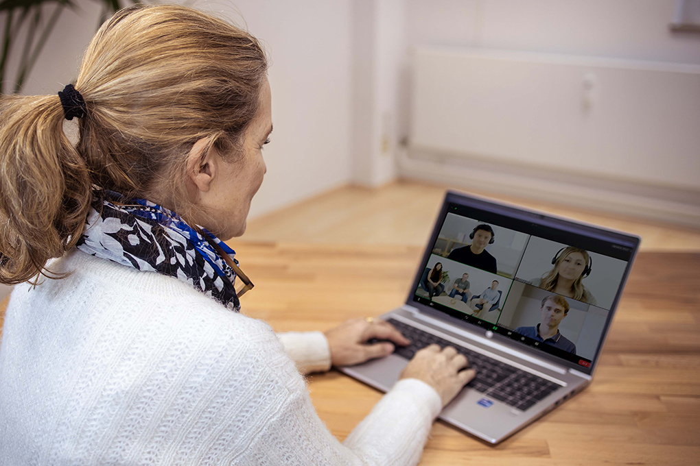 Webinar Annette Lienhart sitzt neben einem Laptop mit Video Live-Meeting.